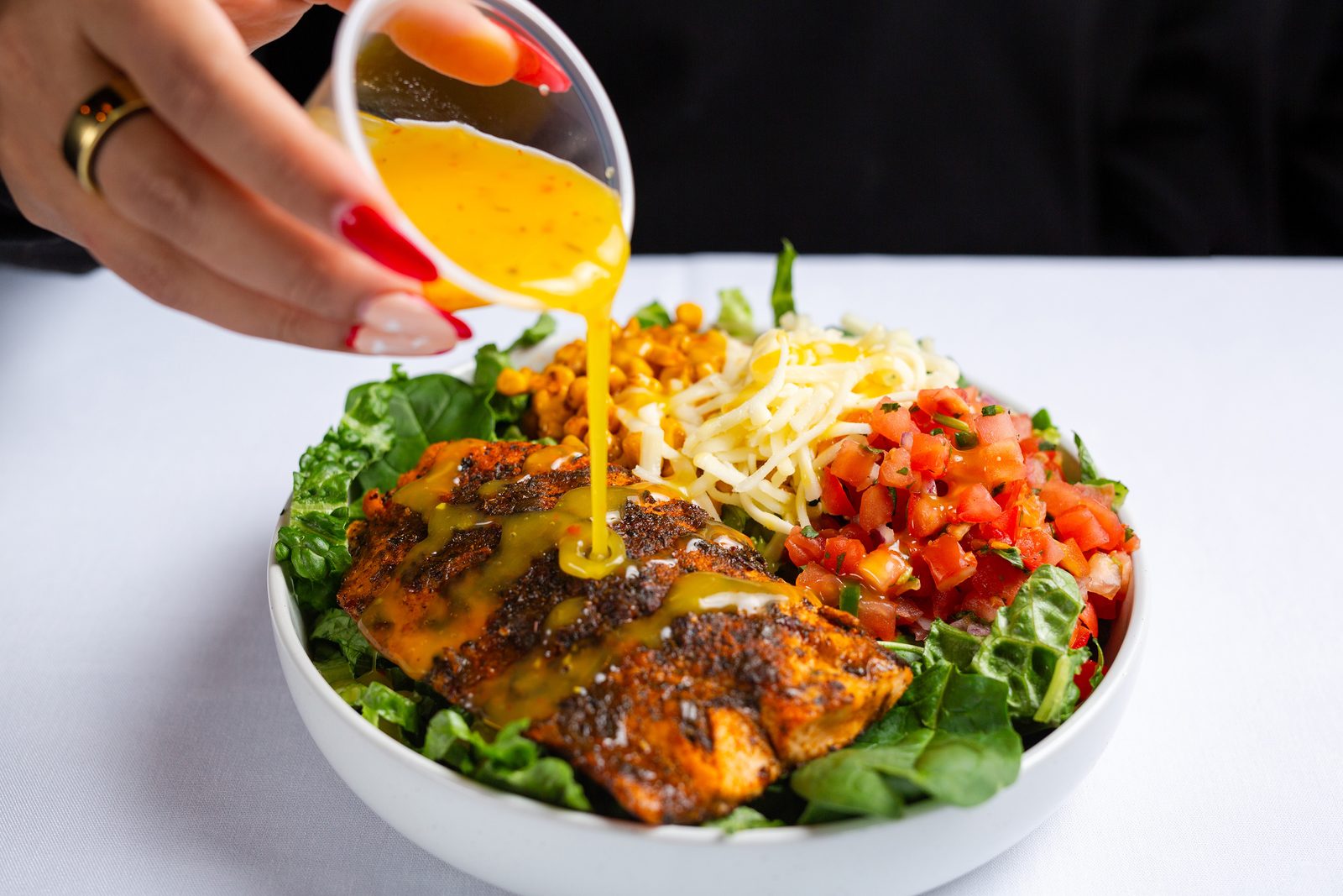 Dressing poured over a blackened bowl