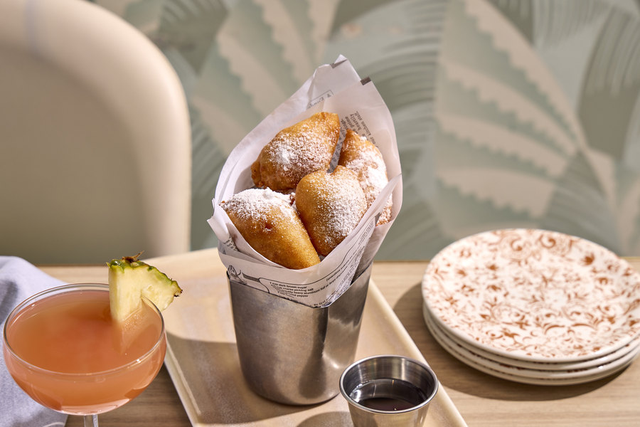 Dawn's Chicken & Waffle Bites in a paper-lined cone with a cup of syrup