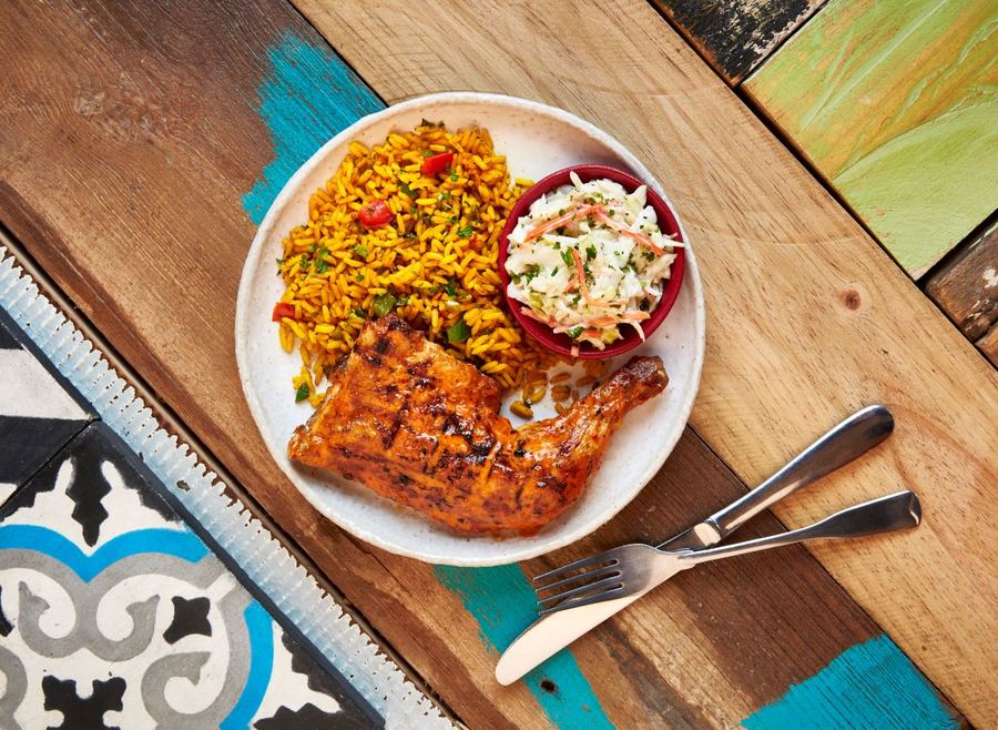 Half a flame-grilled PERi-PERi chicken with Portuguese rice and coleslaw at Nando's