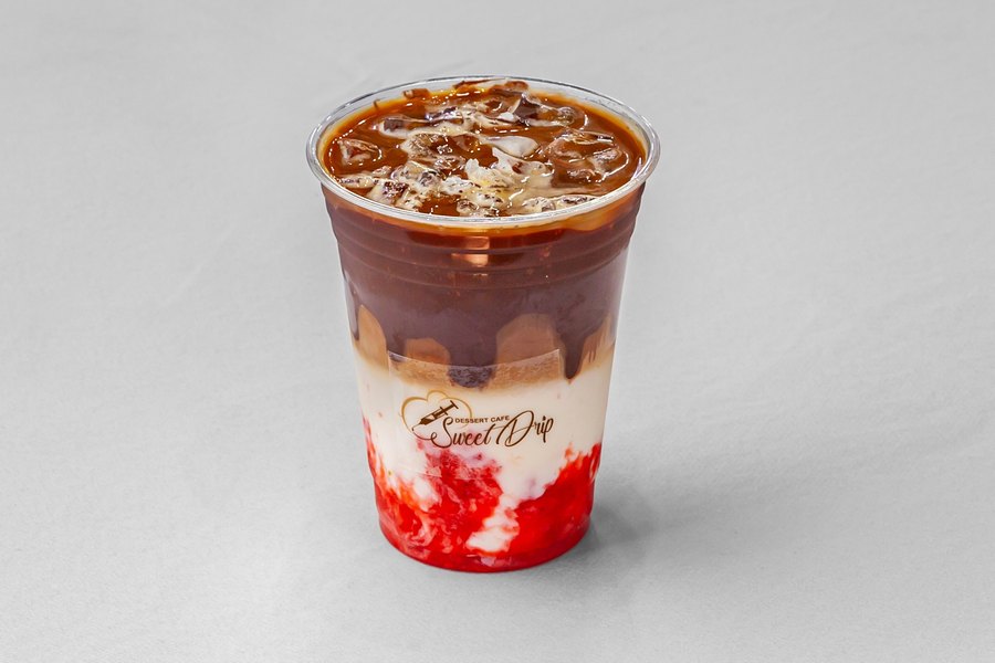 An iced latte in a Sweet Drip cup, espresso over milk and ice